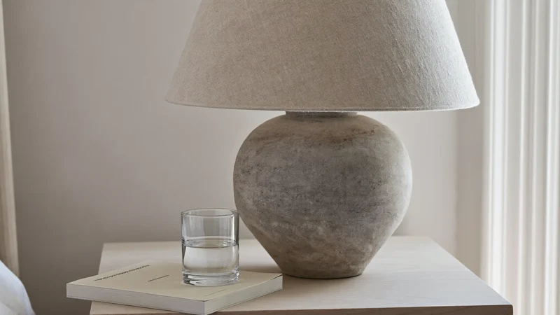 Ceramiczna lampa stołowa z lnianym kloszem na szafce nocnej